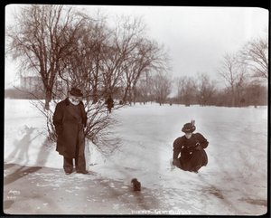 Ansicht einer Frau, die ein Eichhörnchen füttert, während ein Mann im Schnee im Central Park, New York, 1898 zusieht